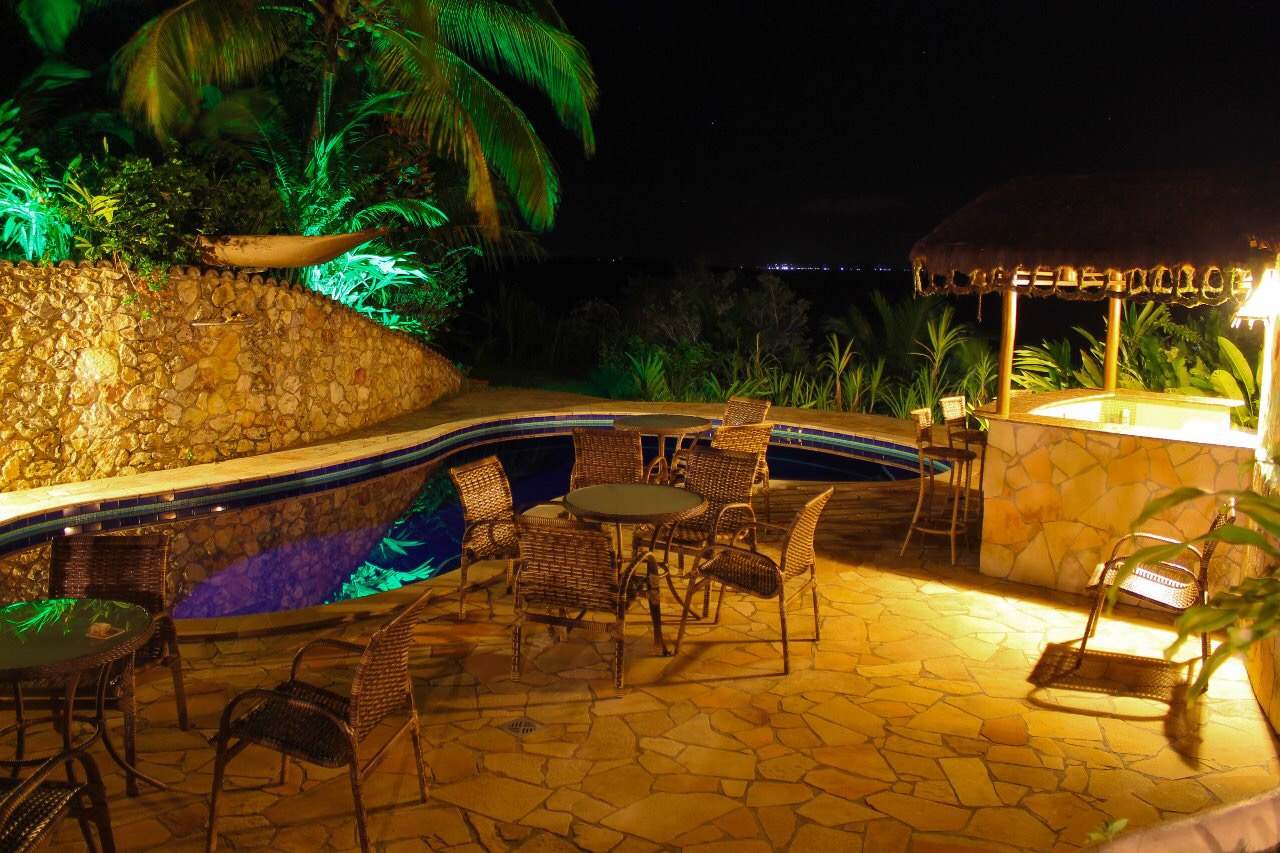 Piscina iluminada à noite com atmosfera intimista