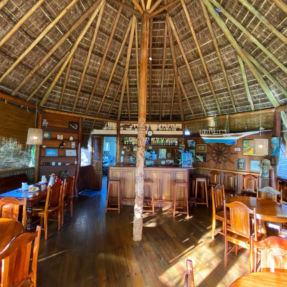 Bar de madeira da Pousada Colibri com mesas preparadas para o café da manhã