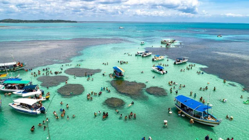 Barcos e banhistas nas piscinas naturais da Volta à Ilha